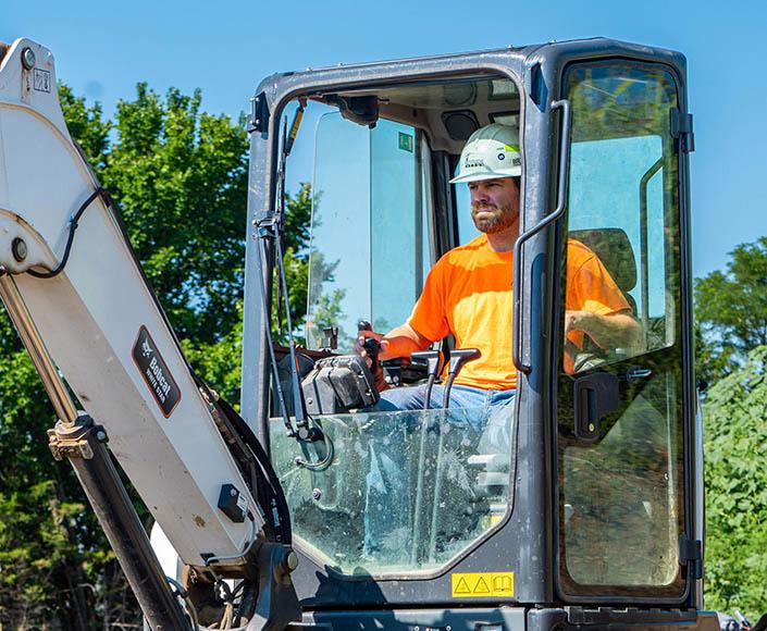 McElroy Excavation technician digging with mini excavator.